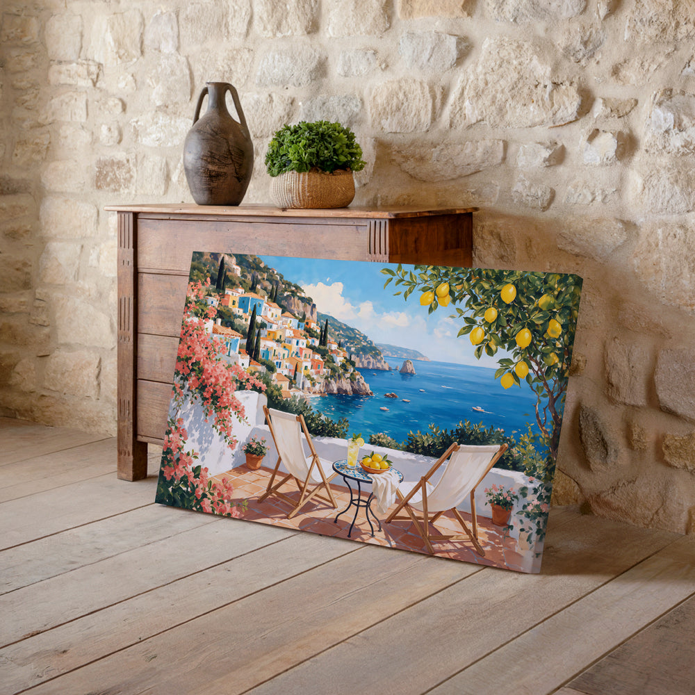 Mediterranean canvas artwork showing two lounge chairs beside a small table overlooking an Italian coastal village
