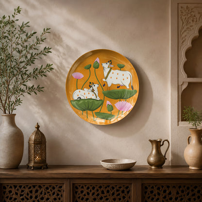 Premium ceramic wall plate inspired by Indian Pichwai paintings with sacred cows and vibrant lotus blooms.