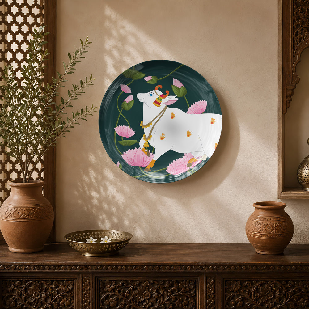 Lotus Guardian ceramic wall plate featuring a sacred white cow surrounded by blooming lotus flowers inspired by Pichwai art.