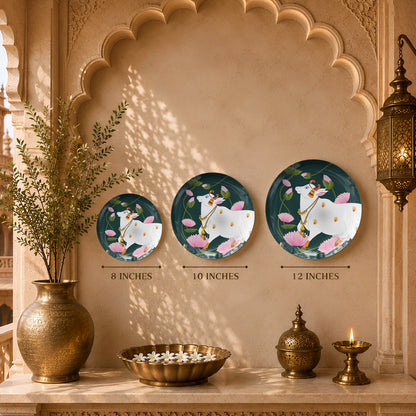 Decorative ceramic wall plate featuring traditional Indian sacred cow artwork and elegant lotus floral motifs.