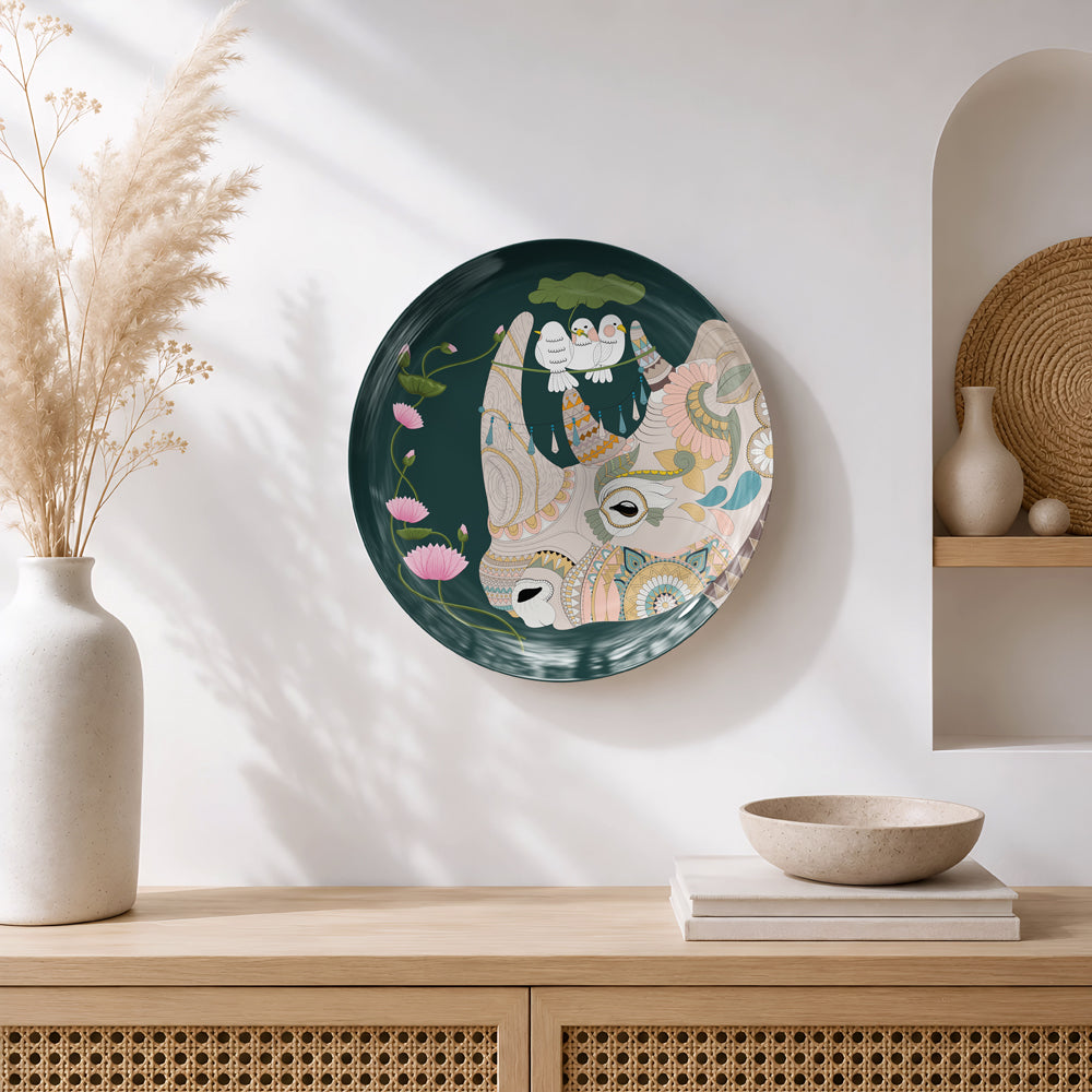 Luxury ceramic wall plate featuring a sacred cow, lotus flowers and white birds on a rich emerald green background.