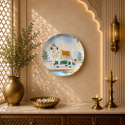 Indian Heritage Series ceramic wall plate showcasing a sacred cow in a royal courtyard landscape.