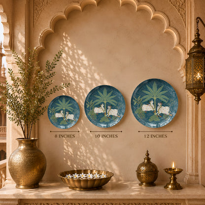 Decorative ceramic wall plate featuring sacred cows surrounded by tropical plants and ornamental patterns.