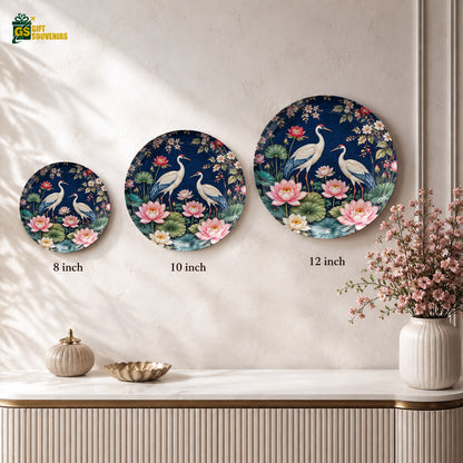 Decorative bird wall plate with white cranes, blue-grey wings and vibrant pink lotus flowers